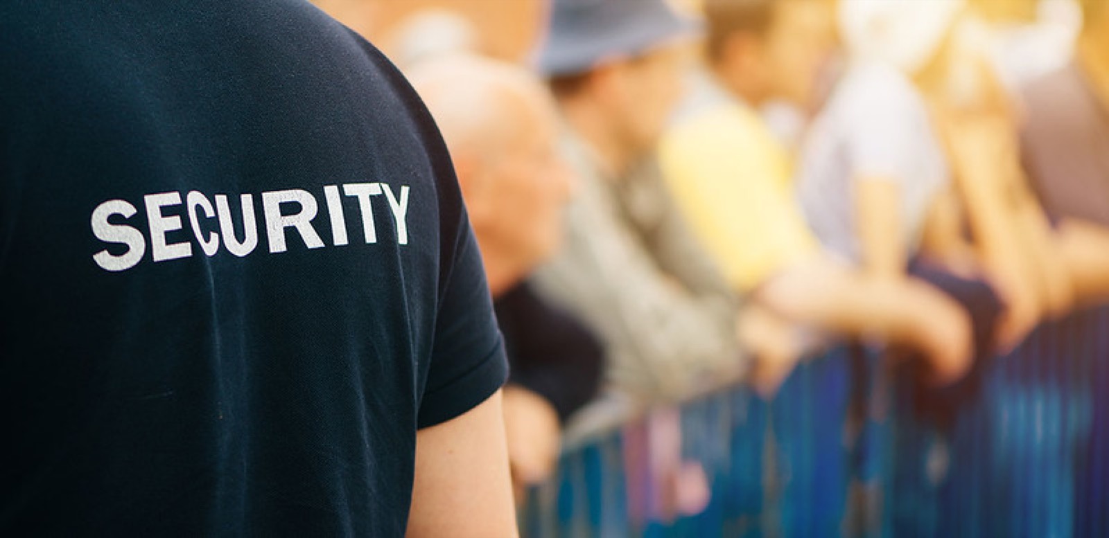 Addetto security con la scritta sulla maglia davanti al pubblico di un evento