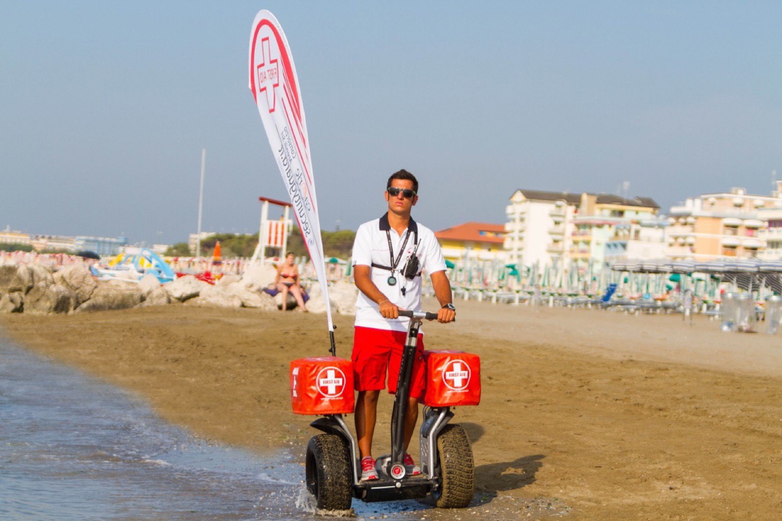 Infermiere su Segway attrezzato con valigette di primo soccorso sul bagnasciuga